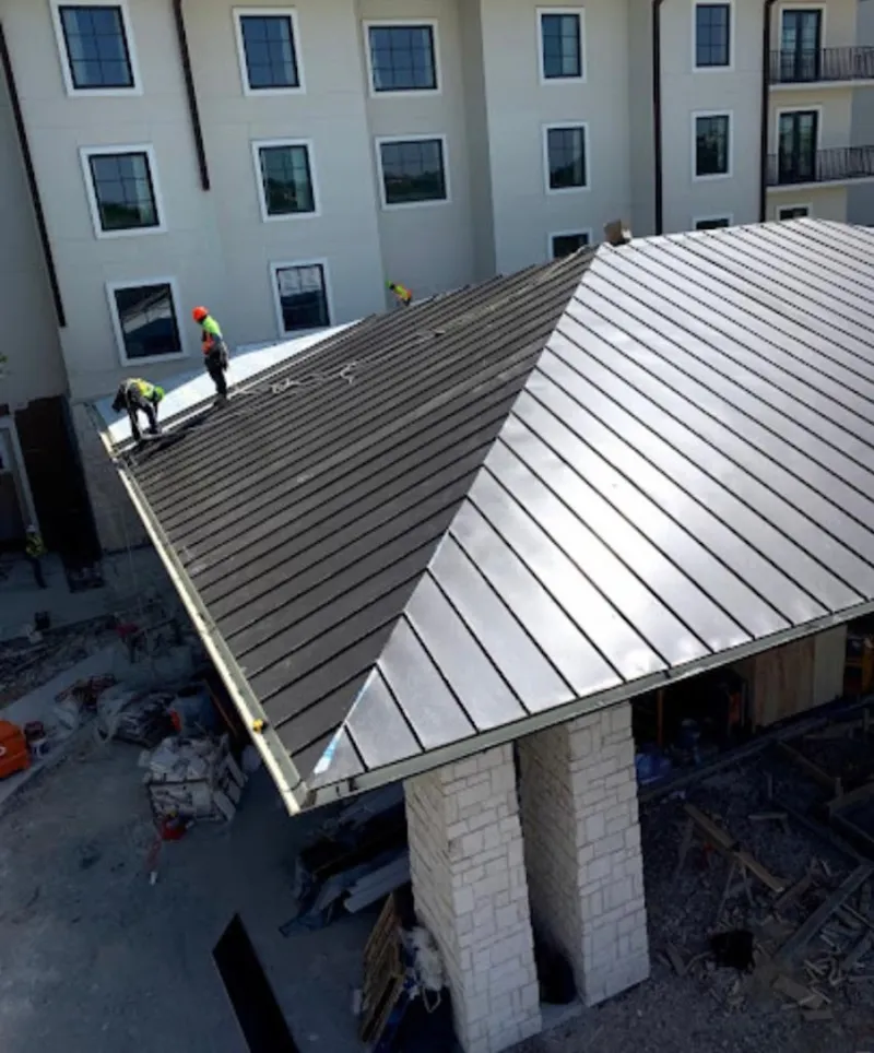 Crew installing standing seam metal roof panels on a commercial project in Cleveland Heights